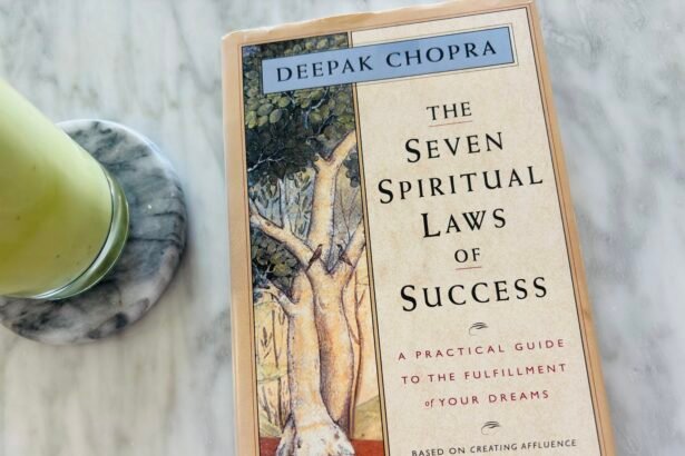 The Seven Spiritual Laws of Success by Deepak Chopra placed on a marble table next to a glass of iced matcha latte