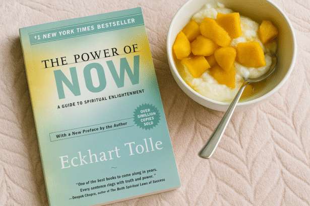 “The Power of Now book beside a bowl of yogurt and mango on a cozy blush blanket”