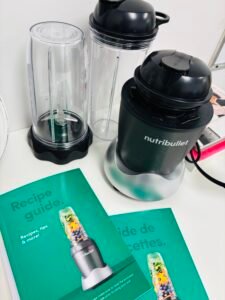 NutriBullet blender with two blending cups and recipe booklets on a white counter