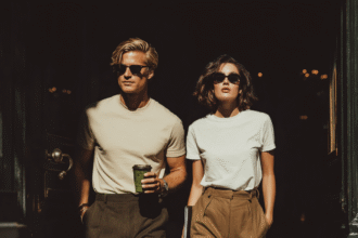 Stylish man and woman wearing minimalist neutral t-shirts and trousers walking confidently in natural light