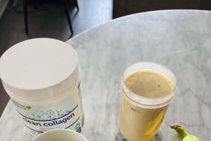 Coffee, collagen powder, protein smoothie, and banana on marble table