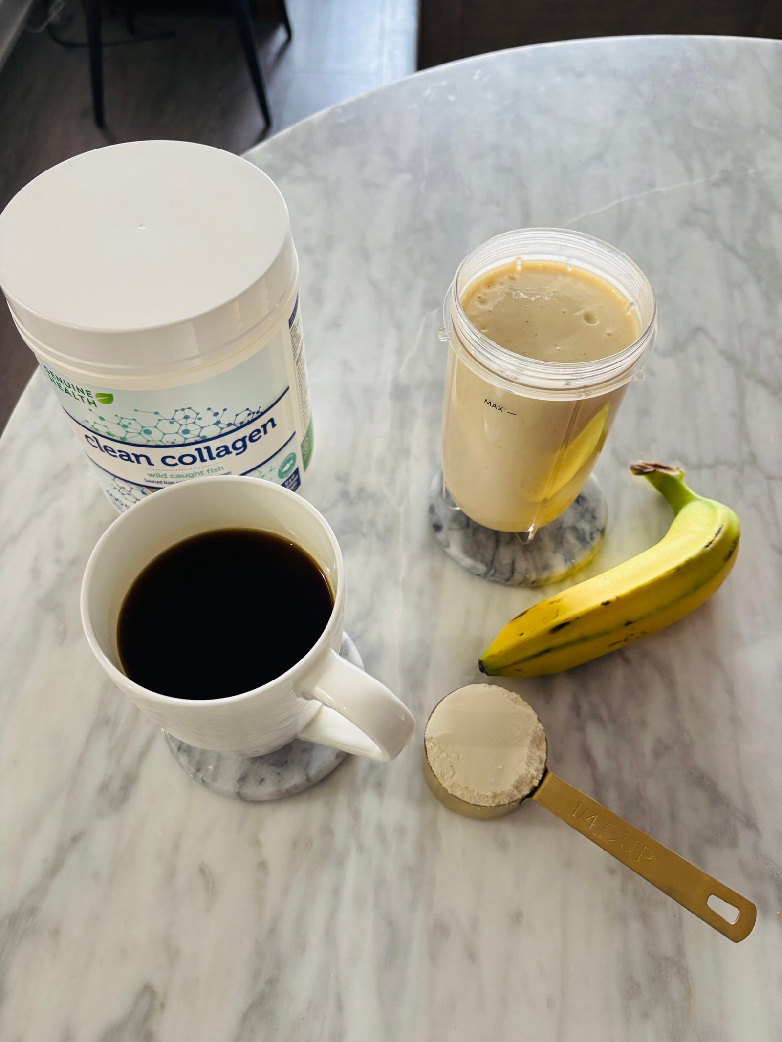 Coffee, collagen powder, protein smoothie, and banana on marble table