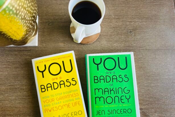 Two Jen Sincero books — You Are a Badass and You Are a Badass at Making Money — on a cozy wooden table with a cup of black coffee