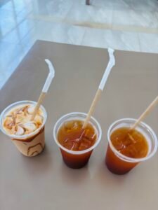 Three iced coffee drinks with paper straws from the coffee and snack bar at Olio Cancun Playa.