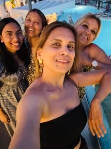 Friends taking a selfie by the ocean during sunset, celebrating connection and happiness.