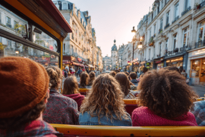 People enjoying an open bus tour through a lively city street at sunset.