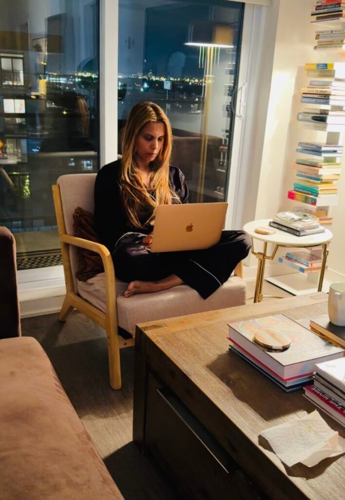 Woman working on a laptop at home at night, representing creative freedom and intentional work