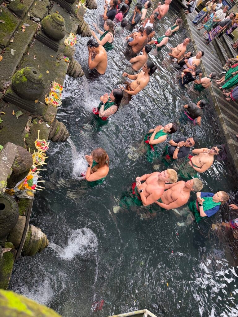 People participating in a water purification ceremony at a temple in Bali