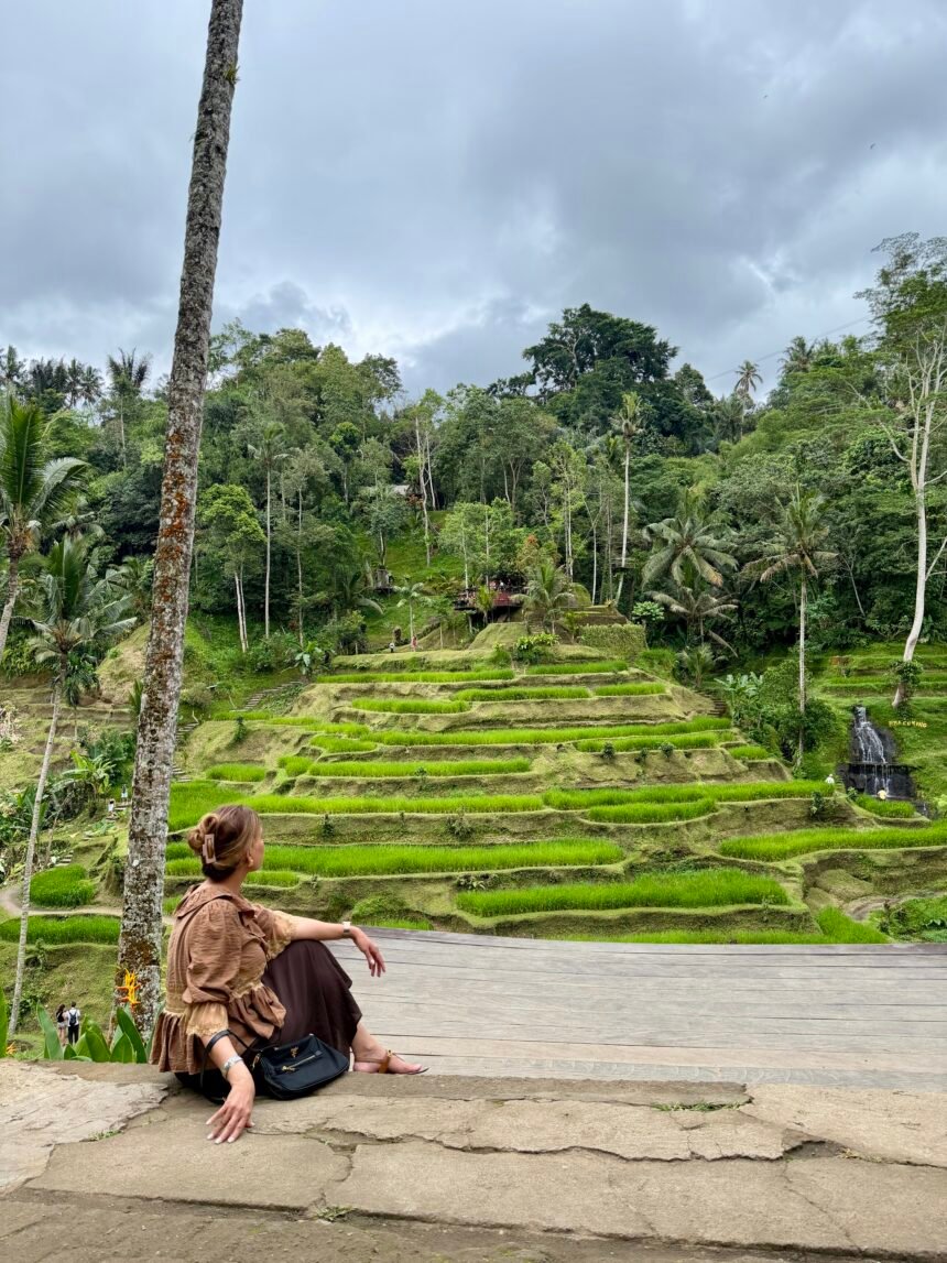Woman sitting and admiring rice terraces in Ubud Bali surrounded by tropical forest