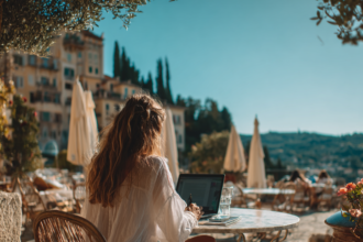 Woman working on a laptop outdoors in a European setting representing time freedom and a location independent lifestyle