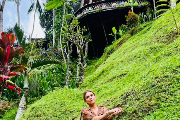 Woman sitting peacefully on stone steps surrounded by lush tropical greenery in Bali, reflecting on freedom, slow living, and personal growth.