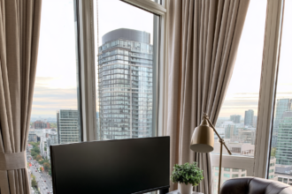 Home office desk with a wide curved ultrawide monitor beside a folded laptop