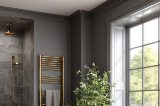 Gold towel racks mounted in a charcoal-tiled luxury bathroom.